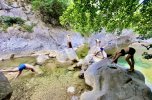 Wanderreiter praktizieren Yoga während einer Pause an einem glasklaren Bergfluss