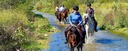 Happy trail riders crossing a river near Besalu in Spain