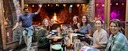 Trail riders enjoying dinner by an open fire in a rural stone house in Catalonia